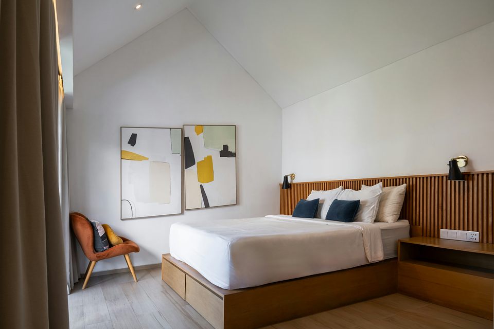 Chambre claire, lit en bois et linge blanc