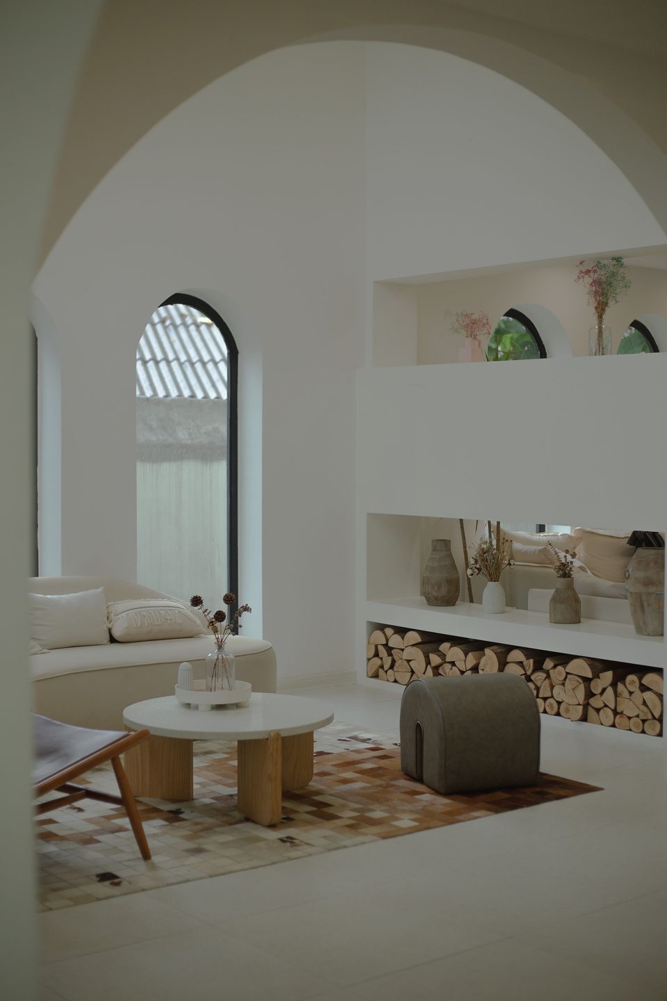 Salon blanc sous une voûte, canapé clair et table basse